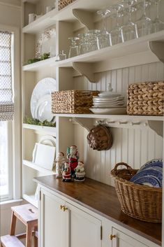 the shelves in this kitchen are filled with dishes and other things to put on them