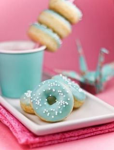 two donuts are sitting on a white plate next to a cup and saucer