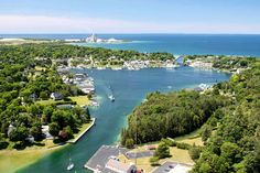 an aerial view of a small town near the water's edge with boats in it