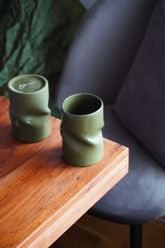 two green cups sitting on top of a wooden table