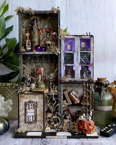 an assortment of items displayed on a table with flowers and plants in vases next to them