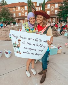 two women are holding a sign that says, may you've got a big hit me excepted to fortify and beyond that you don't give me little