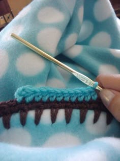 someone is crocheting the stitches on a blue and white blanket