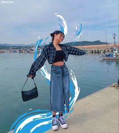 a woman standing next to the water holding a purse