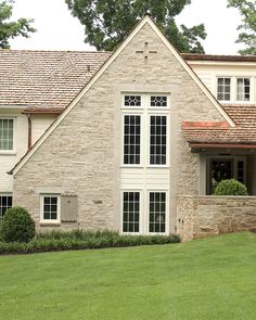 a large brick house sitting on top of a lush green field