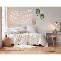 a white bedroom with string lights on the wall