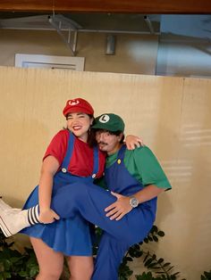 two people dressed as mario and luigi are hugging each other