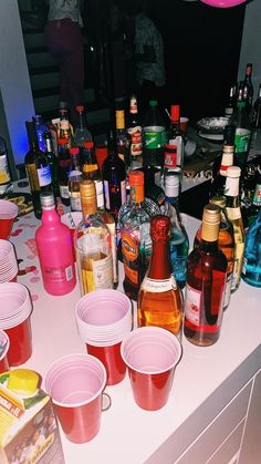 many different types of alcohol are on the counter next to each other in plastic cups