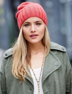 a woman wearing a red hat and green jacket