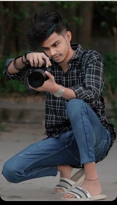 a man kneeling down while holding a camera