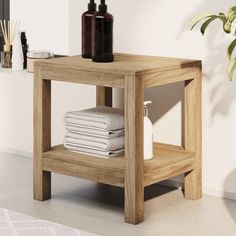 a wooden table with towels on it and a brown bottle next to the end shelf