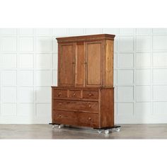 an old wooden dresser with two drawers and wheels on the bottom, in front of a white brick wall