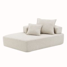 a white couch with two pillows on it and one pillow is folded over the back