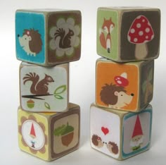 a stack of wooden blocks with animals and mushrooms on them