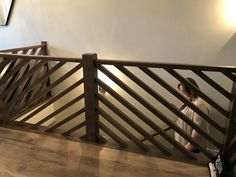 a woman standing on top of a wooden stair case next to a wall with a mirror