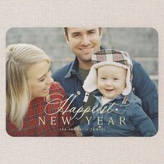 a man and woman holding a baby in front of a christmas card with the words happy new year on it