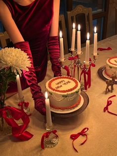 a woman sitting in front of a cake with candles on it