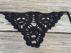 a black crocheted cow's head on a wooden surface