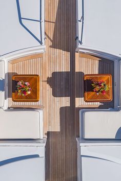 an overhead view of a boat deck with two televisions and flowers on the table