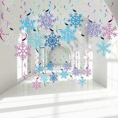 snowflakes and streamers are hanging from the ceiling in a room with white walls