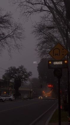 a street sign on the side of a road with trees and buildings in the background