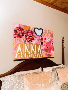 a bed with two pillows and a painting on the wall above it that says delta gama