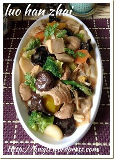 a white bowl filled with meat and veggies on top of a purple place mat