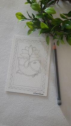 a pencil sitting on top of a piece of paper next to a plant with leaves