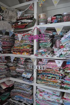 the shelves are filled with many different fabrics