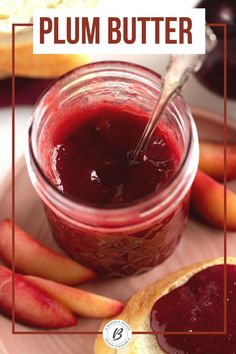 a glass jar filled with plum butter next to sliced apples and bread on a plate