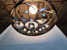 an artistic light fixture hanging from the ceiling in a room with white walls and ceilings