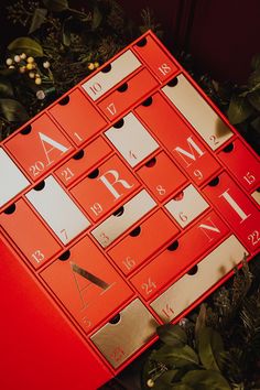 a bunch of red boxes with numbers on them sitting next to some plants and leaves