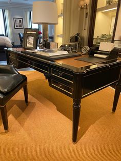 an office with a desk and chair in front of a large mirror on the wall