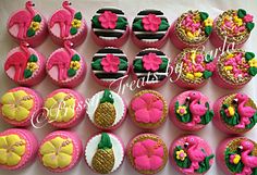 cupcakes decorated in pink, yellow and green icing are arranged on a table