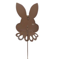 a brown clock with an animal face on it's face and ears, hanging from a metal pole