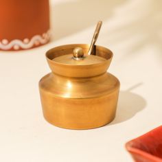 a small brass container with a spoon in it