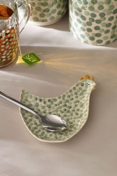 a spoon sitting on top of a plate next to cups