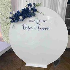 a white sign with blue flowers on it that says engagement or upper & tamba