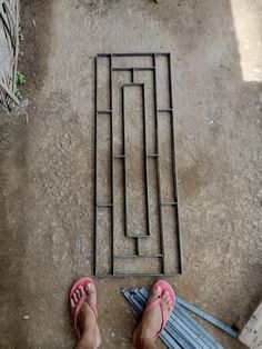 a person standing in front of a metal grate with their feet on the ground