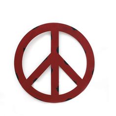 a red peace sign sitting on top of a white wall