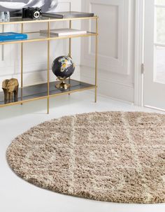 a round rug on the floor in front of a shelf with books and other items