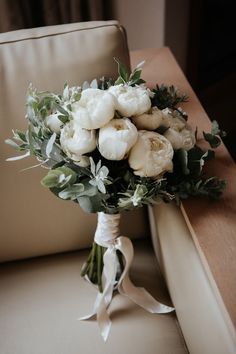 a bridal bouquet sitting on top of a couch