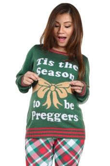 a woman wearing an ugly christmas sweater with the words tis the season to be preggers