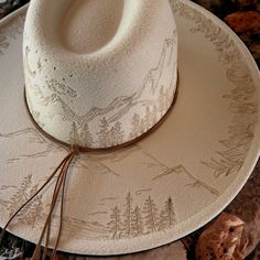 Wide Brim Hat in Light Taupe Burned Hat using Pyrography Techniques. All art is applied freehanded. Each Hat is a One of a Kind. Each Hat made by PIPER comes with a Macramé Wall Hat Hanger and Travel Bag. Hats are sealed for weather and wear. Mountain Burned Hat, Aztec Burned Hat, Trending Hats For Women, Sunflower Burned Hat, Felt Hat Burning Designs, Custom Cowgirl Hats, Hat Customization, Pyrography Techniques, Different Hat Styles