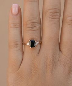 a woman's hand with a black and white diamond ring on her left hand