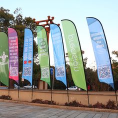 several banners are lined up on the side of a wall in front of a building