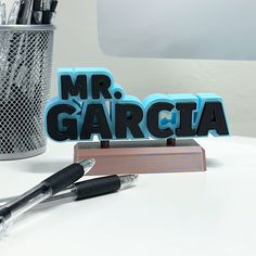 an office desk with pens, markers and magnets in the shape of mr & mrs garciaa