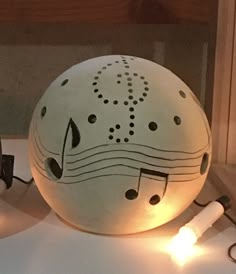 a white ball with musical notes on it sitting on a table next to some lights