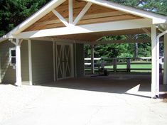 a covered parking lot with a dog sitting in the shade under an attached carport