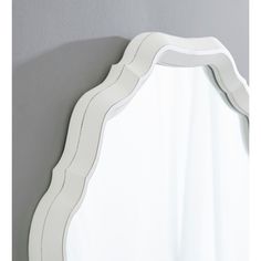 a white mirror hanging on the side of a wall